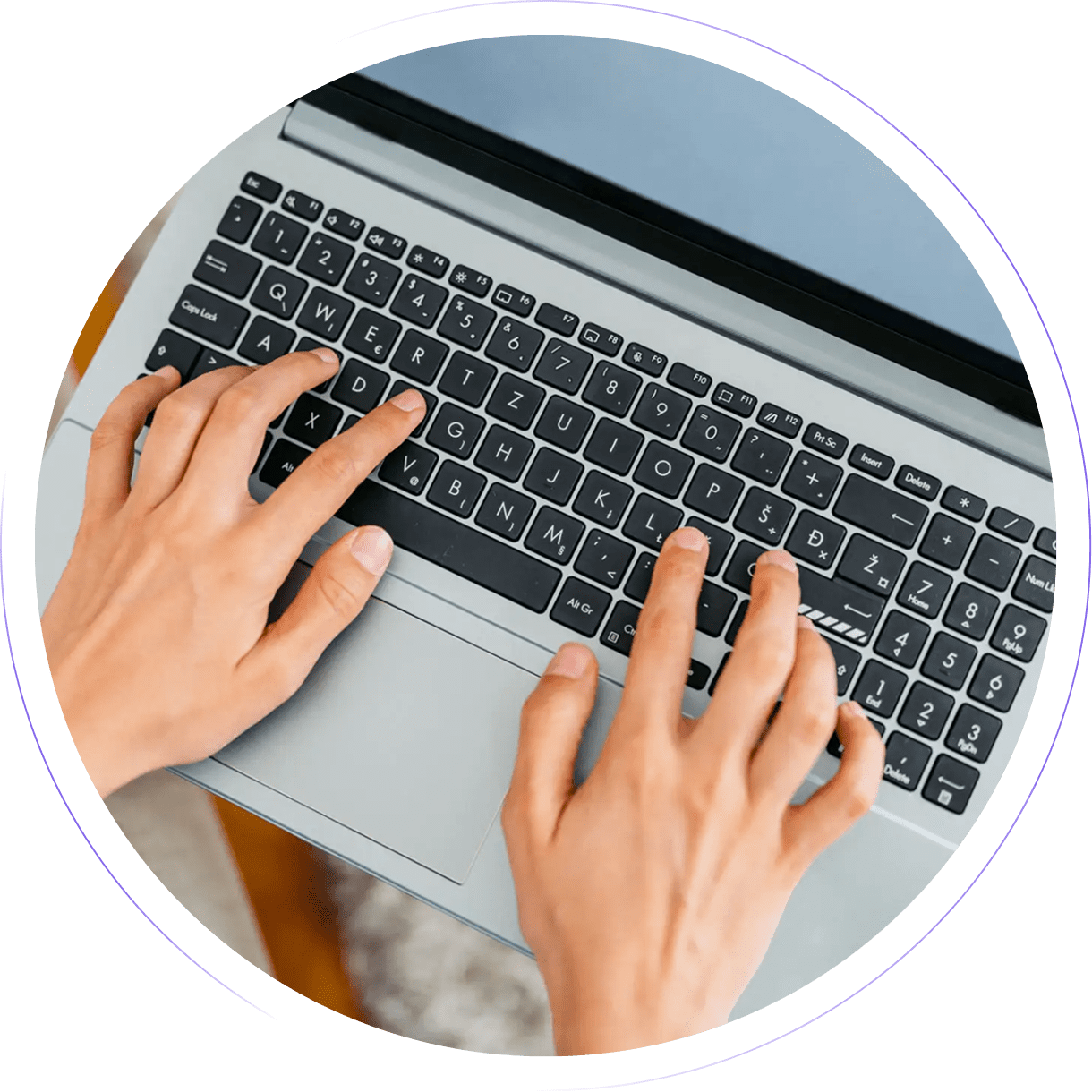 Hands typing on a laptop keyboard.