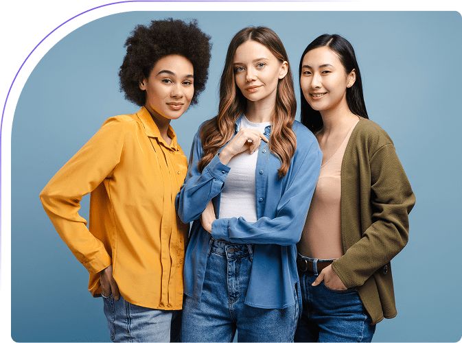 Three women posing against a blue background.